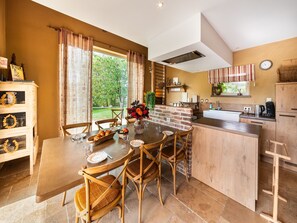 A cozy kitchen with a dining area, wooden furniture, and a view of the outdoors. - Bertrix charming 2-bedroom holiday home (Bertrix)