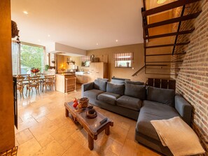 A modern living room with a sofa, coffee table, and a staircase. - Bertrix charming 2-bedroom holiday home (Bertrix)