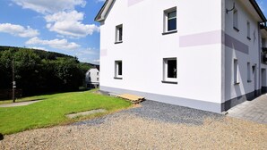 A two-story building with a white facade and multiple windows.