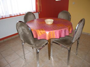 A dining area with a round table, four chairs, and a tablecloth. - Apartment in Ondenval near Malmedy (Ondenval/Waimes)