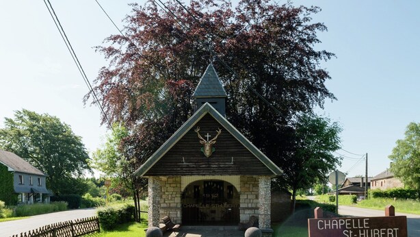 A small chapel with a stone facade, a pointed roof, and a deer head above the entrance.