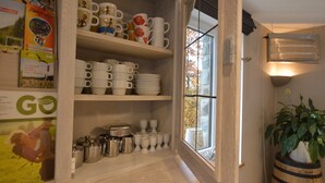 A kitchen with white cabinets, a window, and a potted plant.