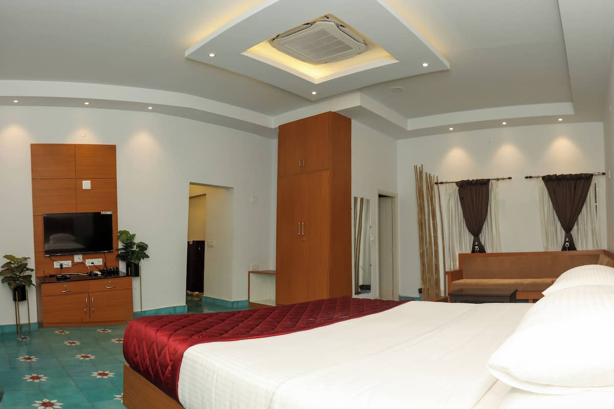 Une chambre d’hôtel avec un grand lit, une télévision, une armoire en bois et un luminaire au plafond.