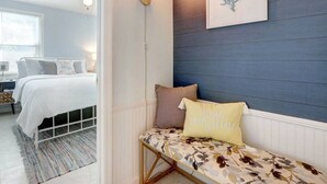 A bedroom with a bed, bedside table, and a wall-mounted light fixture. - Marsh Magic 2 Bed 1 Bath Beach House w Marsh View (Tybee Island)