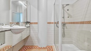 Ein Badezimmer mit Duschkabine, Badewanne und Waschbecken mit Spiegel.