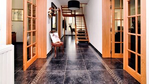 A hallway with wooden doors, a staircase, and a chair with a cushion. - Countryside Escape for 9 (Honnay)