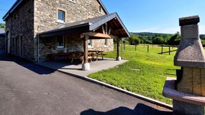Un bâtiment en pierre doté d’un patio couvert et de tables de pique-nique.