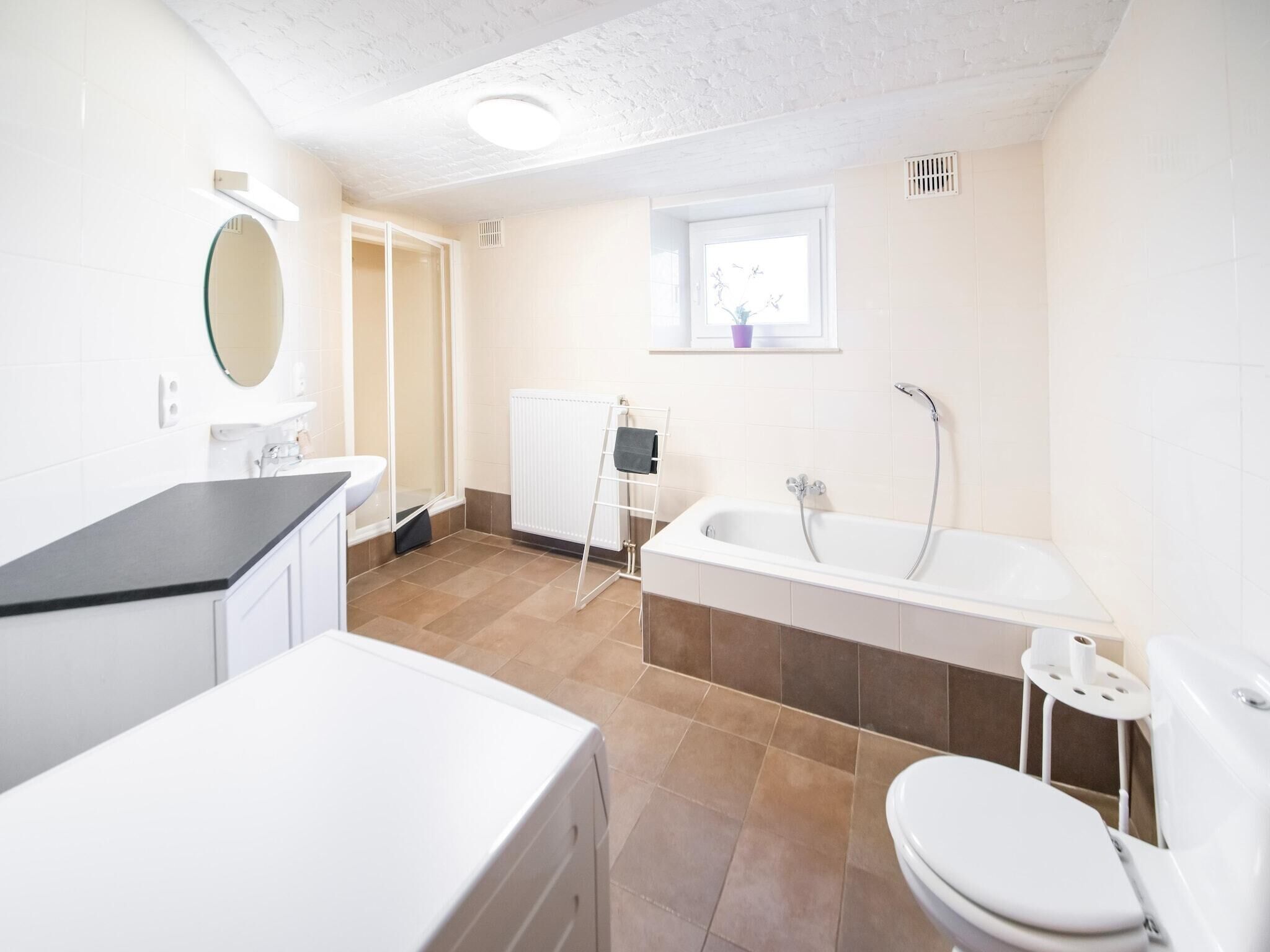A modern bathroom with a bathtub, toilet, and sink.