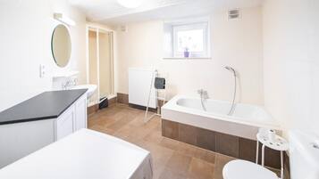 A modern bathroom with a bathtub, toilet, and sink.