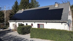 Et hus med skråt tag beklædt med solpaneler.