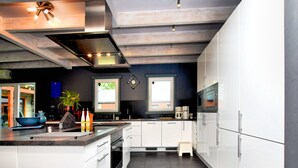A modern kitchen with white cabinets, a large island, stainless steel appliances, and a window providing natural light. - Beautiful villa with heated outdoor pool (Manhay (lamormenil))