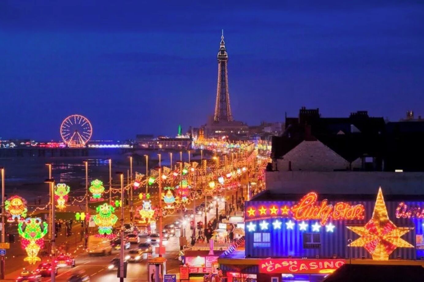 A brightly lit street with neon signs and a Ferris wheel in the background.