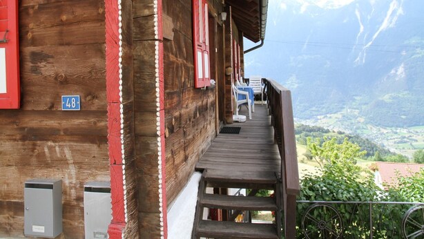 A wooden building with a balcony overlooking a mountainous landscape. - Boutique Apartment in Valais with Balcony (Guttet-Feschel)