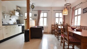 Eine geräumige Küche mit Holzausstattung und ein Essbereich mit einem Holztisch und Stühlen.