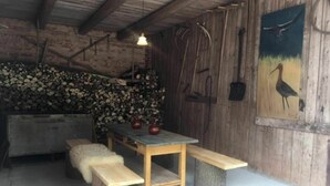 Un interior rústico de madera con una mesa, bancos y un cuadro de un pájaro.