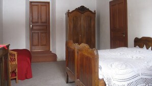 Une chambre à coucher avec un lit en bois, une armoire et une porte.