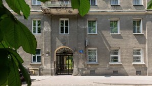 A multi-story building with a central entrance, large windows, and a balcony.