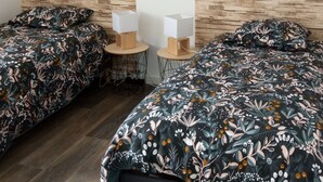 A room with two beds, a wooden headboard, a hanging light fixture, and a framed sign on the wall. - Maison Neuve de 2023, Plain Pied, 2 Chambres, à 10 Minutes à Pied de la Plage (Fréhel)