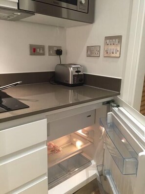 A kitchen with a built-in toaster, a refrigerator with a freezer drawer, and a countertop.