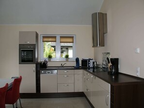 Een microgolfoven, een kookplaat, een vaatwasser, een kinderstoel