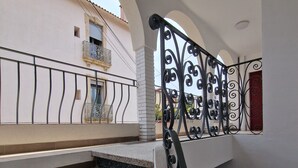 A staircase with a black wrought iron railing leading to a balcony.
