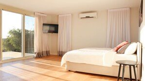 A bedroom with a bed, a TV mounted on the wall, and a window with curtains. - Gorgeous Mansion by Caesarea's Greatest Beach-hosted by Sweetstay (Hof HaCarmel)