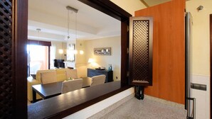 Una cocina moderna con un espejo grande, un comedor con sillas y una mesa, y una encimera de cocina.