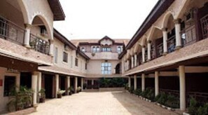 A courtyard with a central open space surrounded by buildings with balconies and windows. - Townhall Hotel & Suites (Lagos)