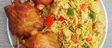 Un plato de pollo frito con arroz y verduras.