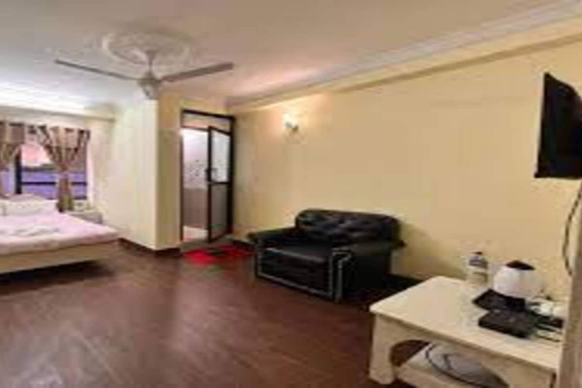 Ein Hotelzimmer mit Bett, Schreibtisch, Stuhl und Deckenventilator.