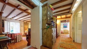 Un salón espacioso con un mueble de madera, una mesa de comedor con sillas y una alfombra colorida.