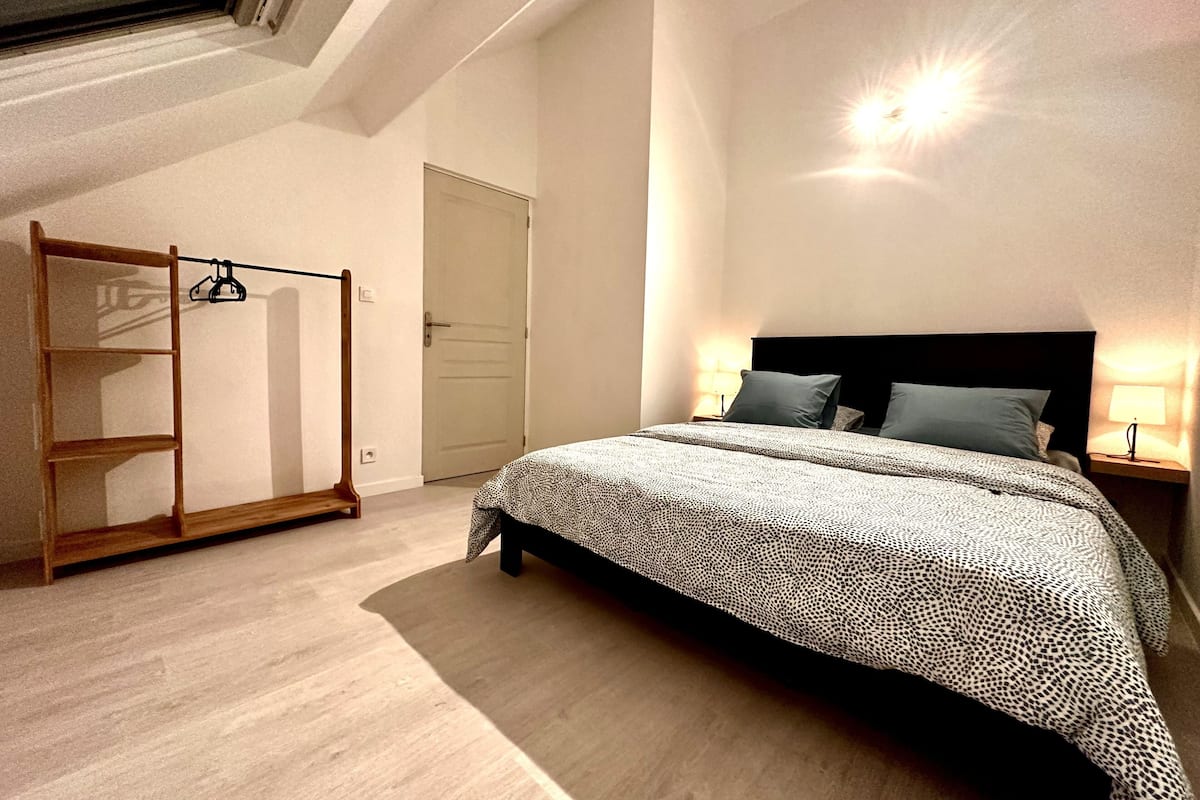 A bedroom with a bed, a wardrobe, and a skylight.