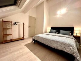 Un dormitorio con cama, armario y tragaluz.