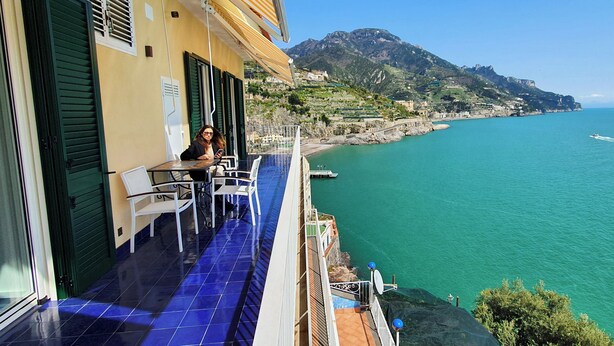 A balcony with a view of the sea and a mountain. - In the blue painted blue (Campania)