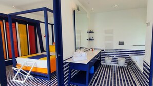 A modern bathroom with a bed, a sink, and a mirror. - In the blue painted blue (Campania)