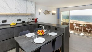 A modern kitchen with a dining area overlooking a beach. - Cosy apartment for 3 guests with WIFI, A/C, TV and balcony (Lloret De Mar)