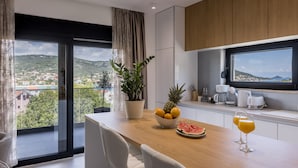 Eine moderne Küche mit einer Holzauskładung, einer Obstschüssel und einem großen Fenster mit Blick auf eine Stadtlandschaft.