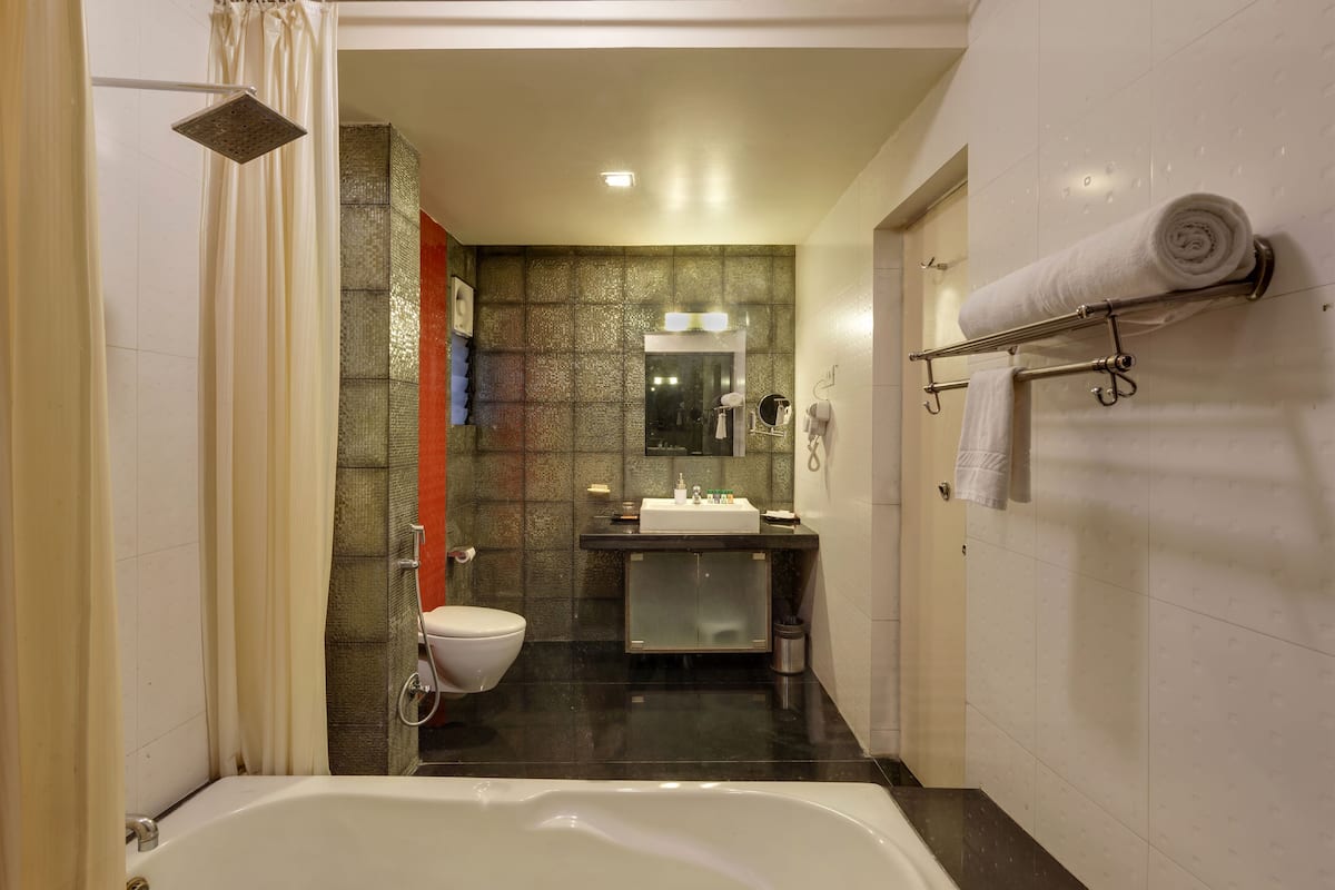 A modern bathroom with a bathtub, toilet, and sink.