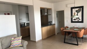 Un appartement moderne comprenant un coin repas, une cuisine et un espace de vie.