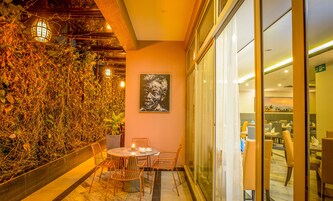 Un restaurante con pared de vidrio, un cuadro y una mesa con sillas.