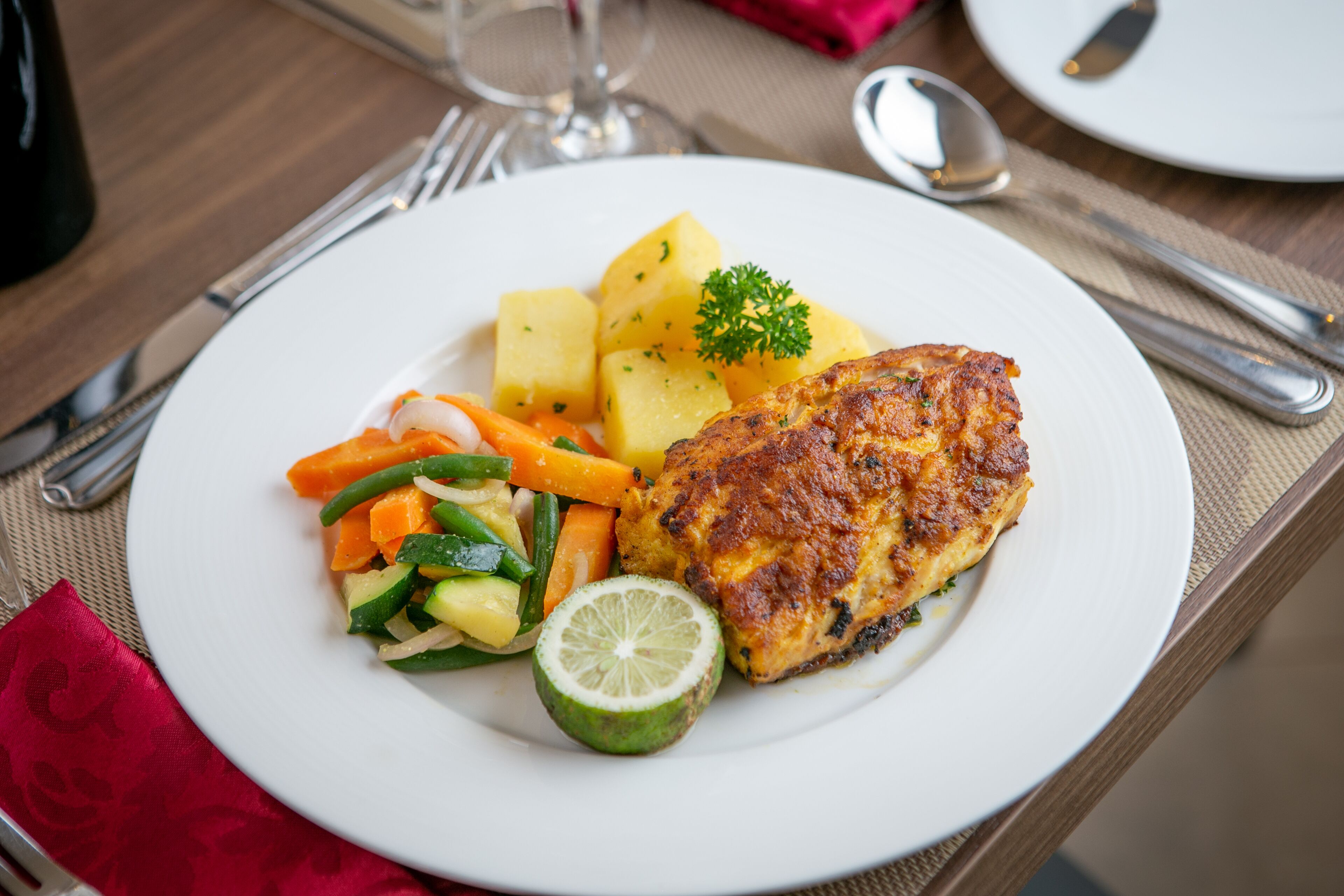 A plate with a piece of grilled chicken, potatoes, and mixed vegetables.