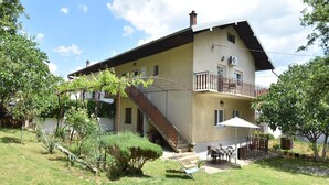 A two-story house with a balcony, a staircase, and a patio area with outdoor furniture. - Apartment in Knin near Knin Fortress (Knin)