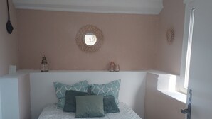 A bedroom with a bed, pillows, a bedside table, a mirror, and a hanging light fixture. - Dépendance D'une Bastide Provençale (MANOSQUE)