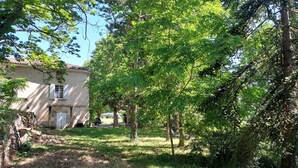 A rustic house with a tiled roof, surrounded by lush greenery and trees. - Dépendance D'une Bastide Provençale (MANOSQUE)
