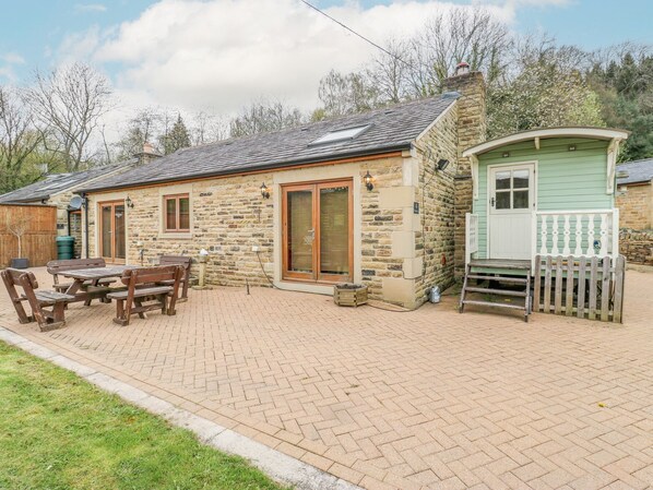 A stone house with a patio, wooden furniture, and a small green shed. - 4 Pheasant Lane (Sheffield)