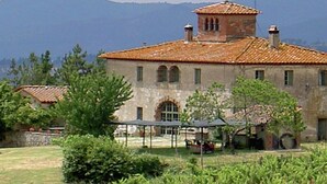 A rustic building with a tiled roof, arched windows, and a small tower-like structure. - Belvilla by OYO Casina Papi (Rufina)
