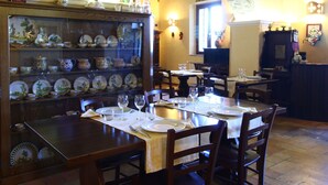 Un comedor con un arco de ladrillo, una colección de platos decorativos y una araña.
