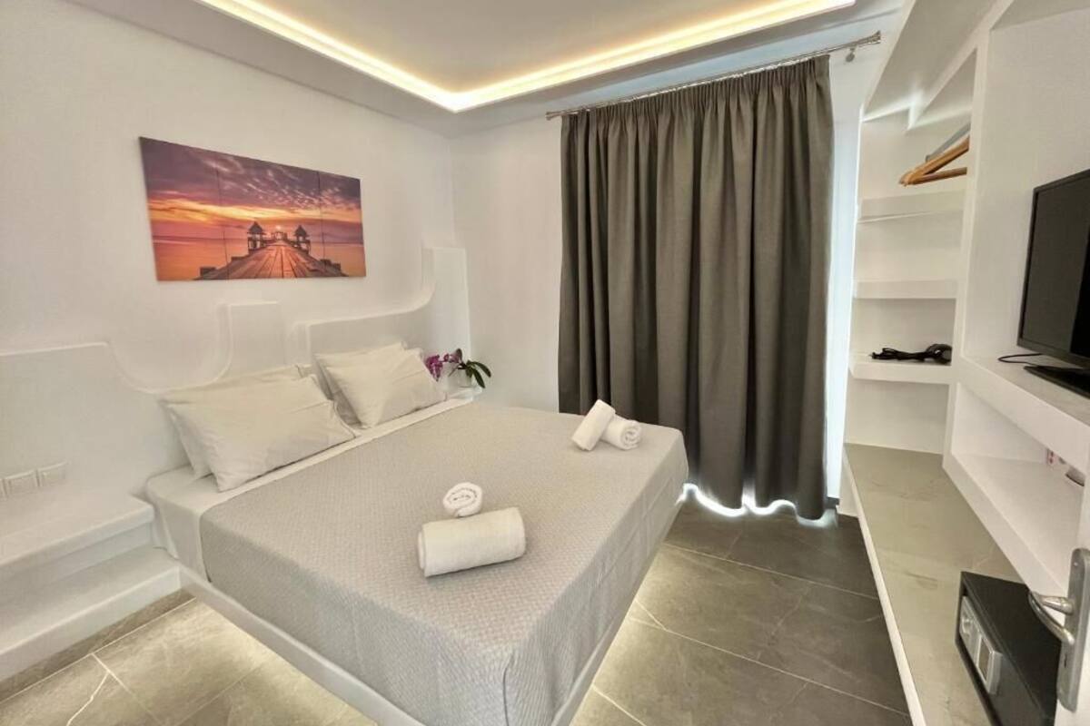 Une chambre à coucher moderne avec un lit, un tableau, une télévision et une armoire.