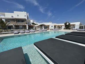 Una piscina al aire libre de temporada, sillones reclinables de piscina