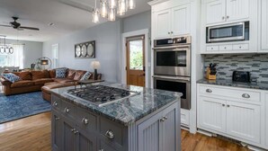 A modern kitchen with white cabinetry, a built-in stove, and a microwave. - Downtown Walk Around (Blue Ridge)